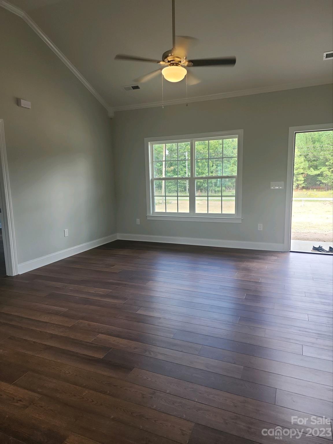 767 Crow Burk Road Pageland, SC 29728 - Photo 8 of 13 an empty room with wooden floor and windows