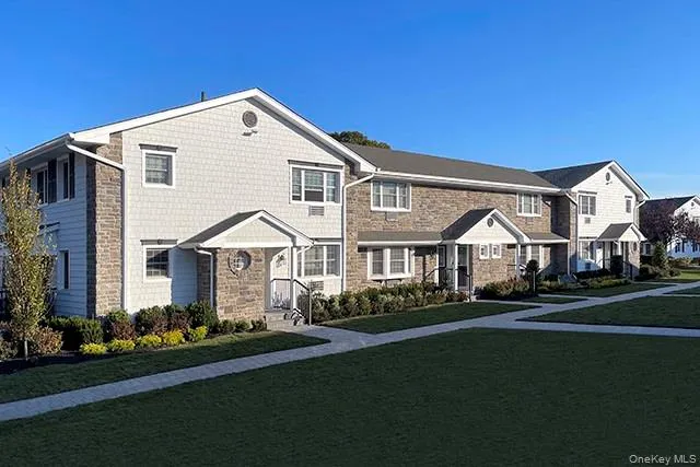 a front view of a house with a yard and trees