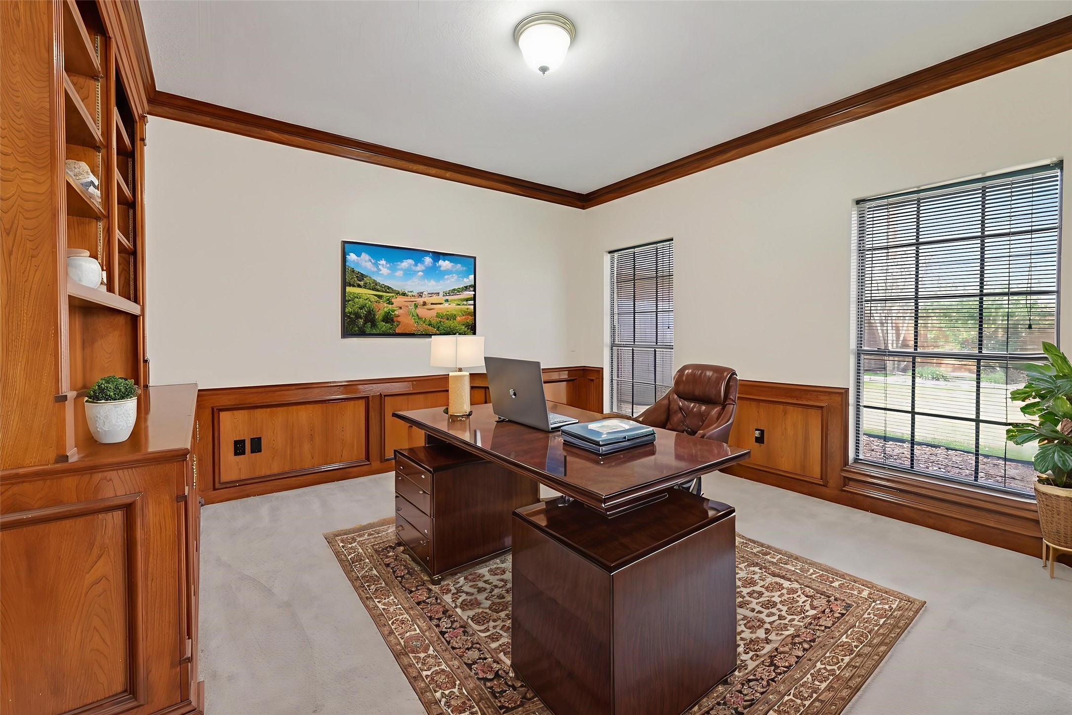 5802 Ashmere Lane Spring, TX 77379 - Photo 14 of 41 This photo showcases a well-lit home office with elegant wooden paneling and built-in shelves. The space features a large window providing natural light, a sophisticated desk setup, and a comfortable chair, creating an ideal workspace.