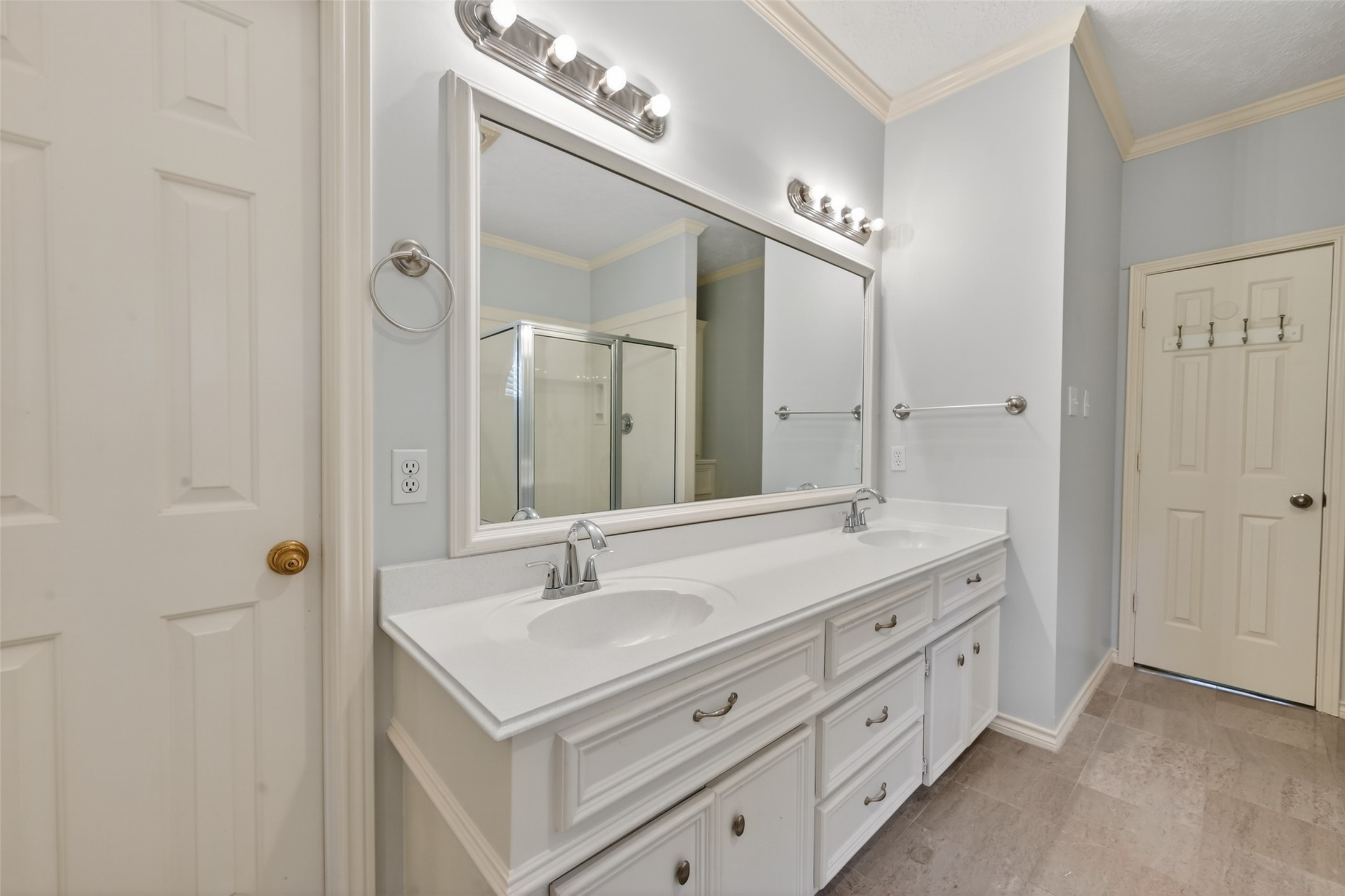 5802 Ashmere Lane Spring, TX 77379 - Photo 19 of 41 This bathroom features a spacious double vanity with ample storage, a large mirror, modern lighting, and a glass-enclosed shower, complemented by neutral tones for a clean, bright look.