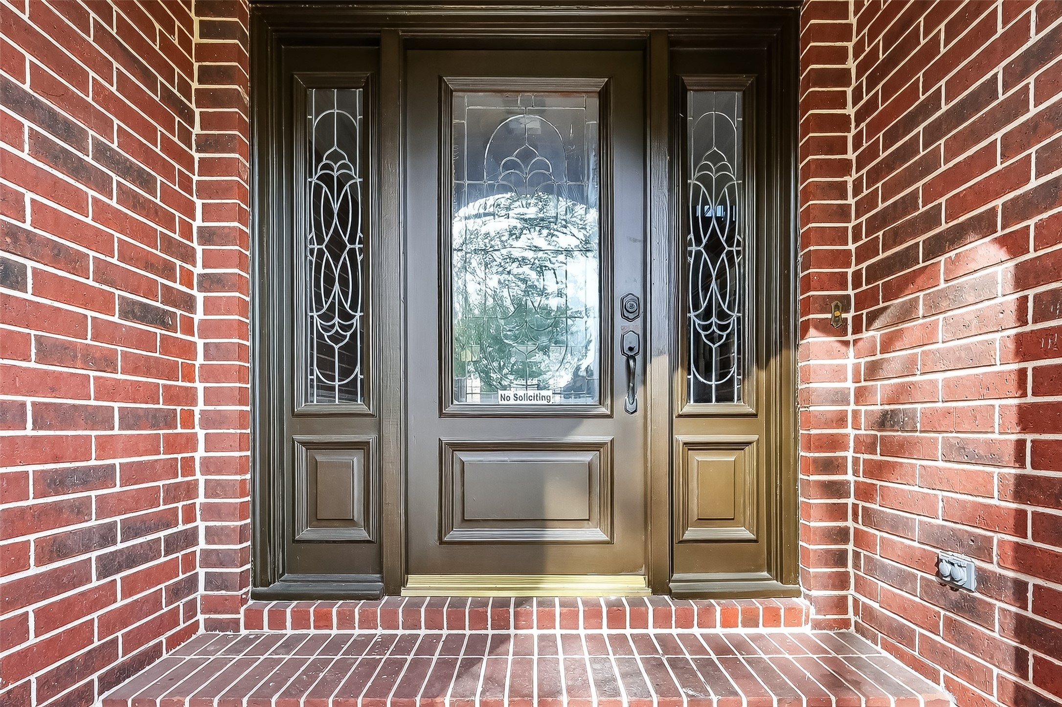 5802 Ashmere Lane Spring, TX 77379 - Photo 3 of 41 This photo showcases an elegant front entry with a sturdy wooden door featuring intricate glass panels, set against a classic red brick facade, offering a welcoming and sophisticated first impression.
