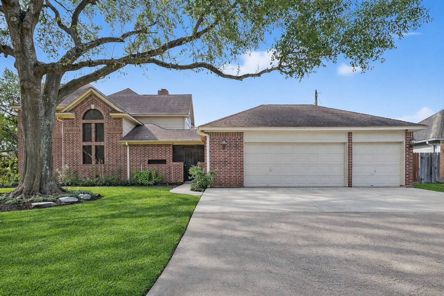 5802 Ashmere Lane Spring, TX 77379 - Photo 39 of 41 This inviting brick home features a spacious three-car garage, a well-maintained lawn, and a large shade tree in the front yard, offering excellent curb appeal and ample parking.