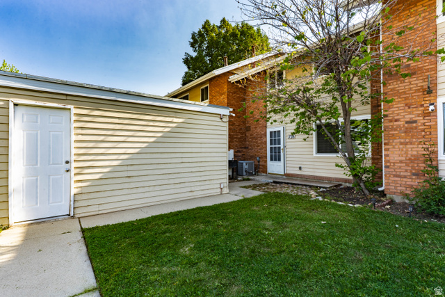728 400 East Orem, UT 84097 - Photo 4 of 30 Private outdoor space featuring a detached garage with a white entry door, concrete patio, and lawn area
