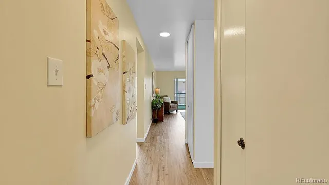 a view of a hallway with wooden floor and a living room