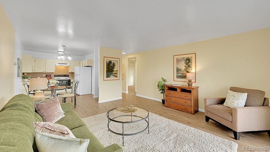 725 South Clinton Street, Unit 1B Denver, CO 80247 - Photo 5 of 22 a living room with furniture and a dining table with wooden floor