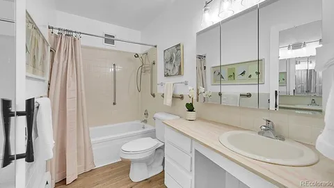 a bathroom with a granite countertop sink toilet and shower
