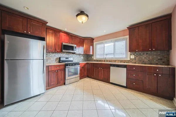 a kitchen with stainless steel appliances granite countertop a refrigerator sink and cabinets