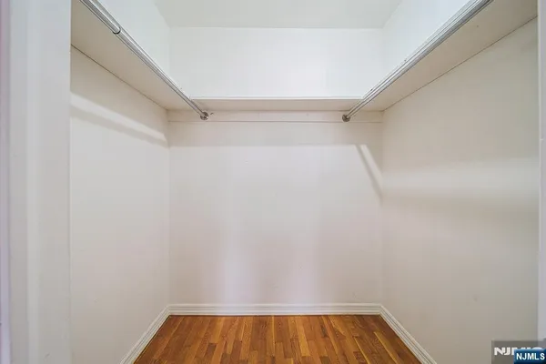 a view of walk in closet with wooden floor