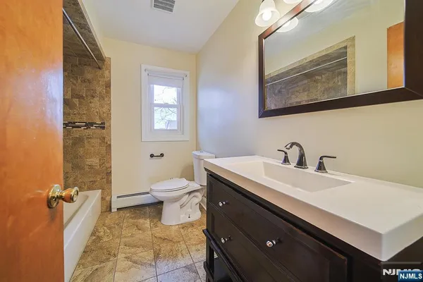 a bathroom with a sink a toilet and a mirror