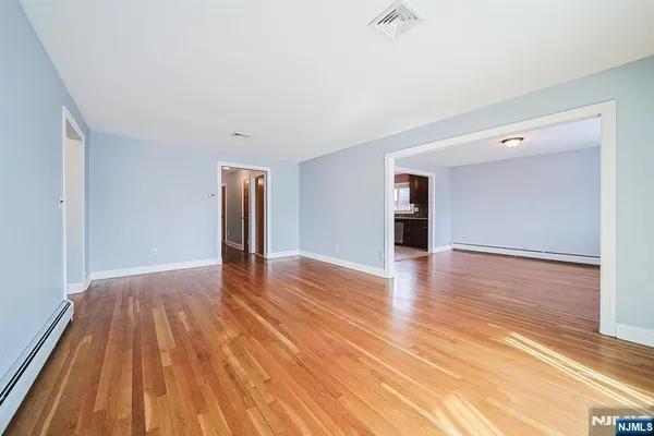 a view of an empty room with wooden floor