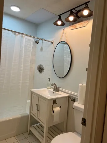 a bathroom with a sink mirror vanity and toilet