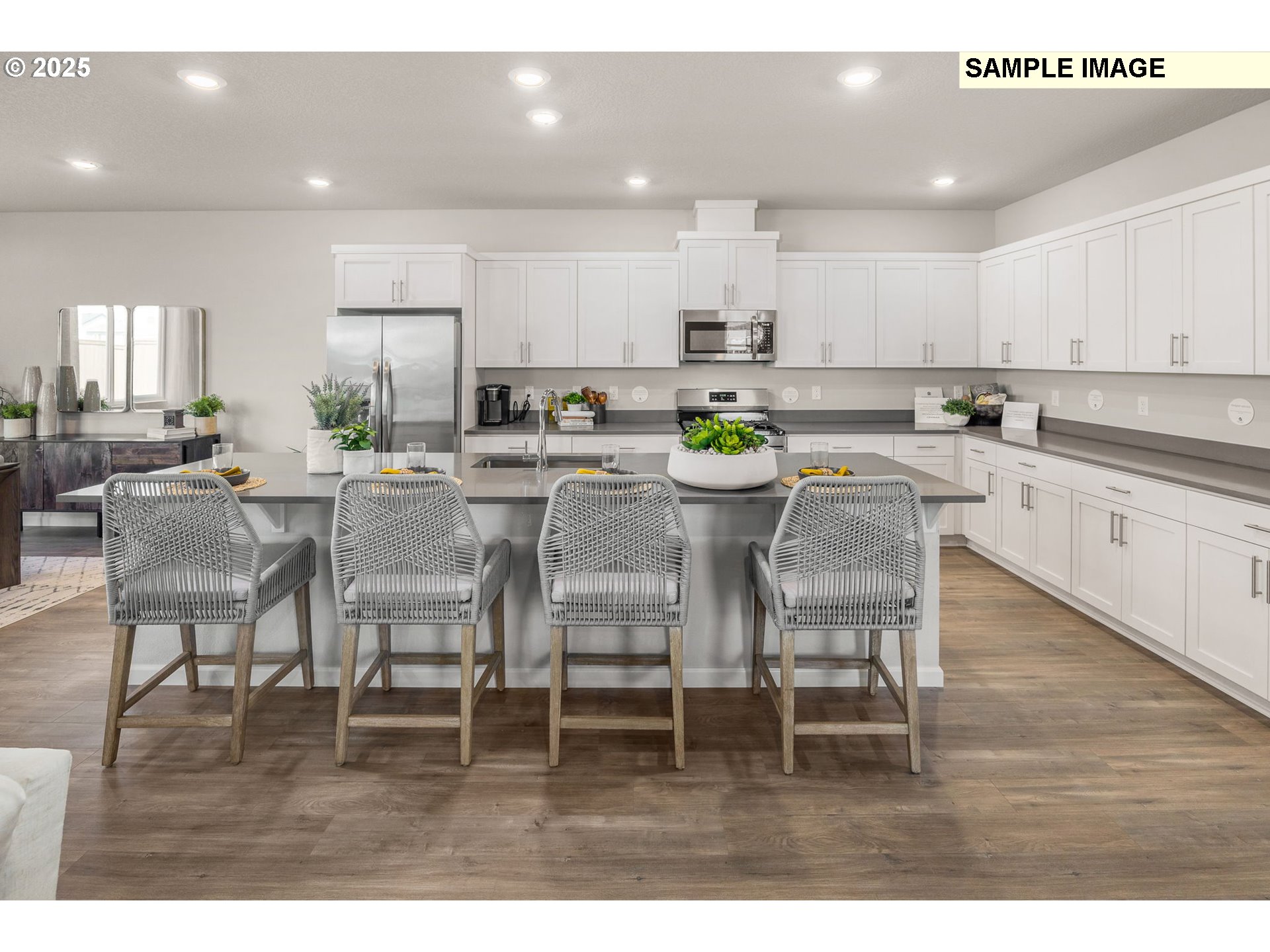 8916 Southwest Choke Cherry Tualatin, OR 97062 - Photo 5 of 29 a kitchen with stainless steel appliances kitchen island granite countertop a dining table chairs and white cabinets