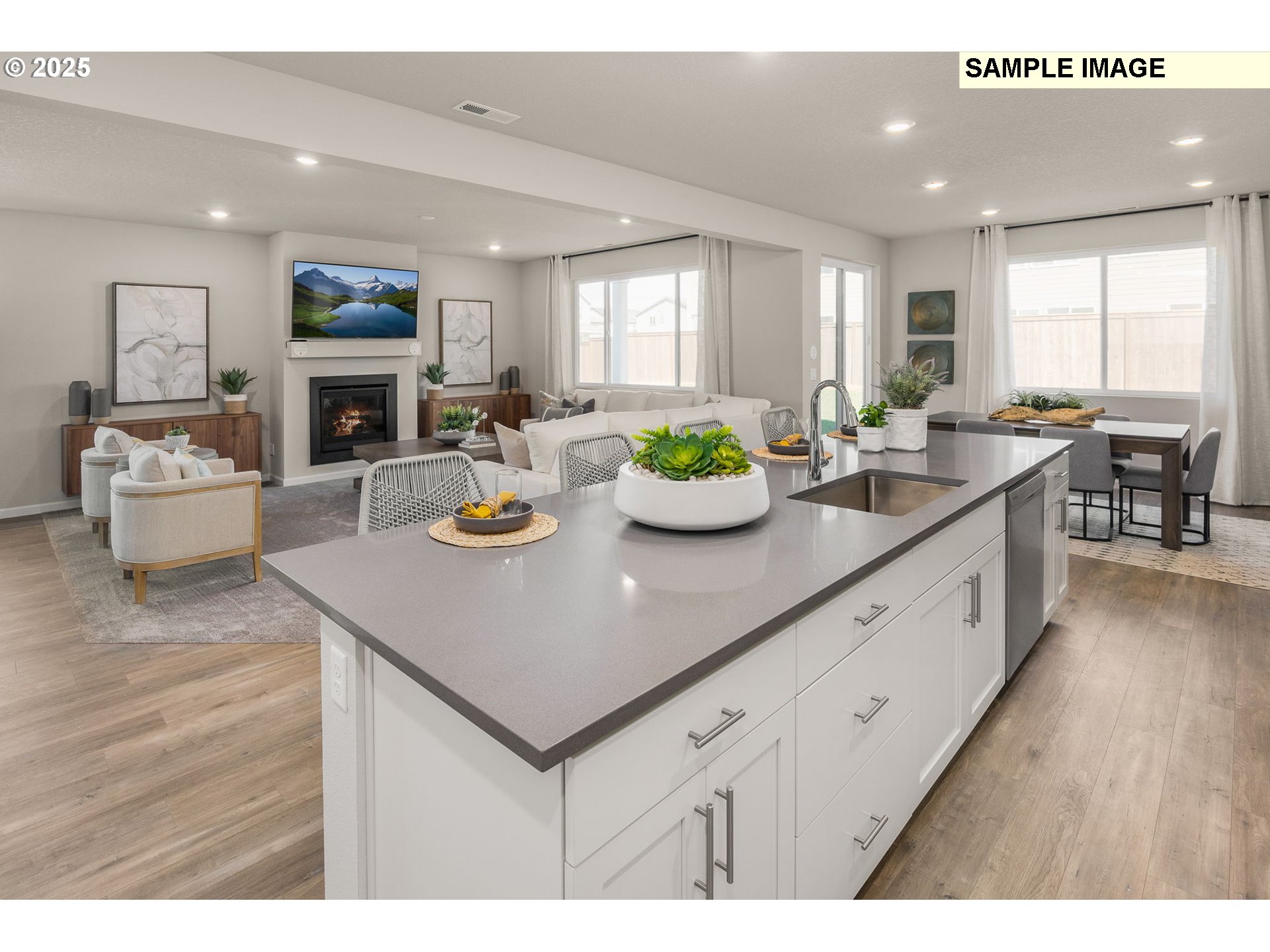8916 Southwest Choke Cherry Tualatin, OR 97062 - Photo 6 of 29 a kitchen with a sink dishwasher white cabinets and couches with wooden floor