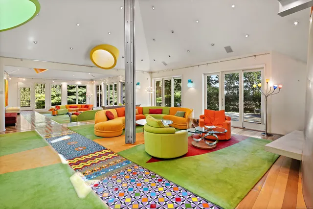 a living room with patio furniture and a large window