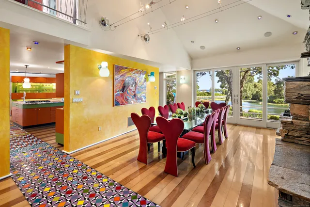 a view of a dining room with furniture one side kitchen view and wooden floor