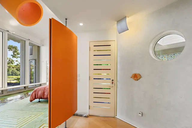 a view of a bedroom with a bed and wooden floor