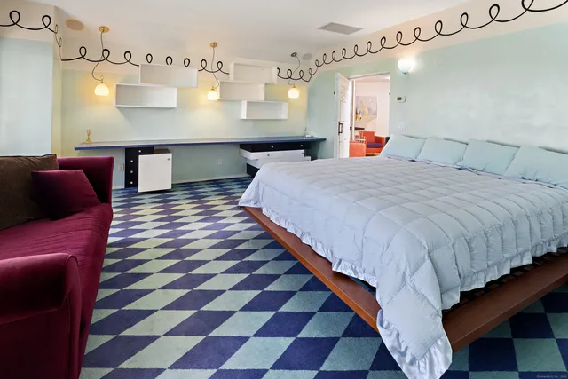 a large bedroom with a bed and wooden floor