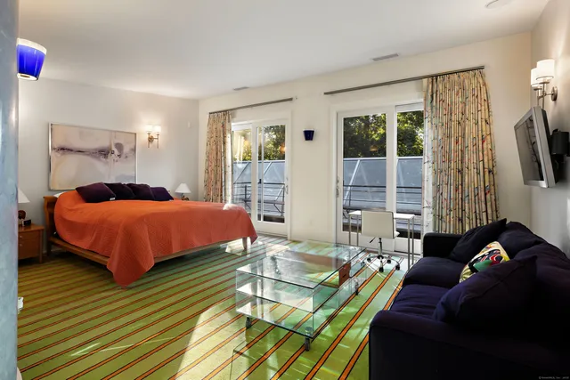 a bedroom with a bed and large windows