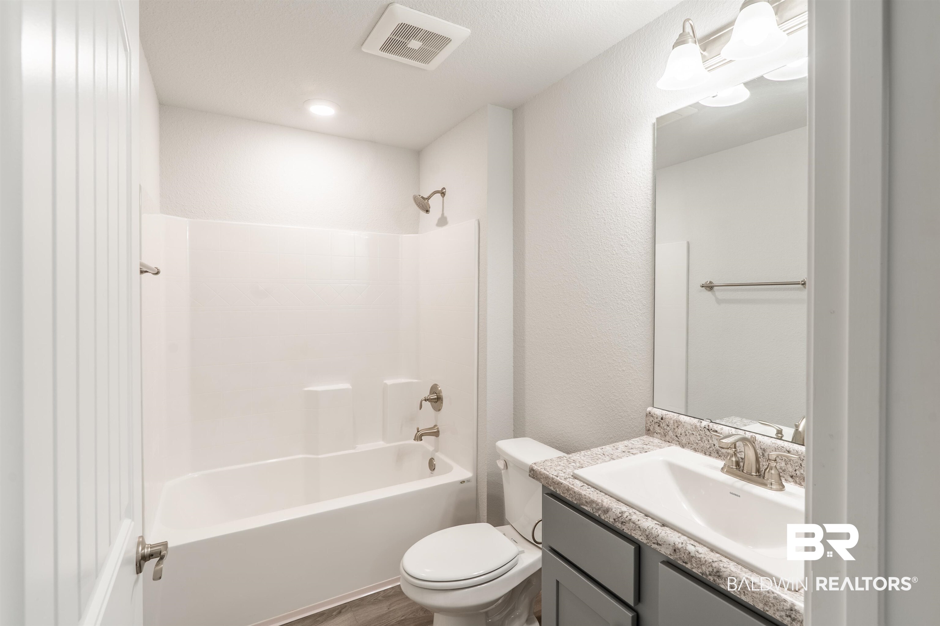 1906 Stonepine Drive South Semmes, AL 36575 - Photo 19 of 30 Full bath with bathtub / shower combination, vanity, dark wood-type flooring, and a textured wall