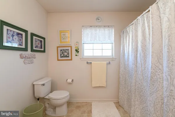 a bathroom with a toilet a sink and a window