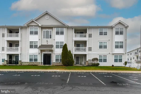 a view of an apartment with a large pool and large trees