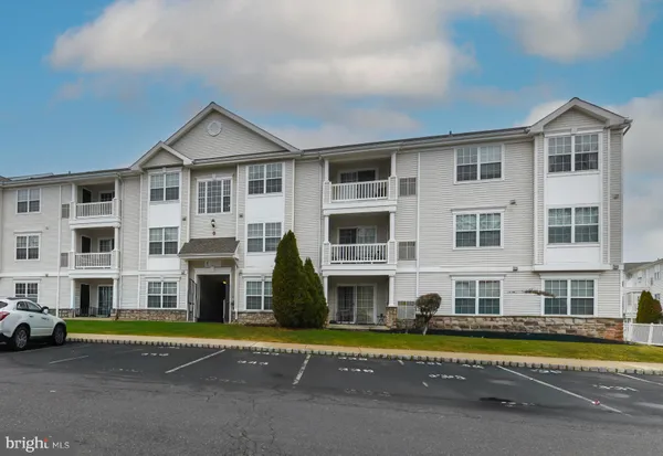 a view of an buildings with a big yard and large trees