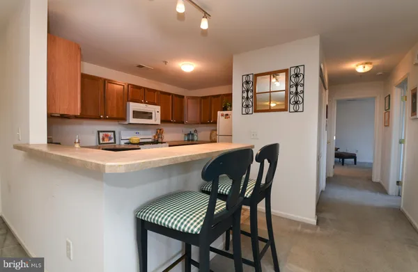 a kitchen with a dining table chairs and a refrigerator