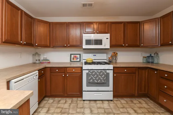 a kitchen with stainless steel appliances granite countertop wooden cabinets a stove top oven a sink and dishwasher