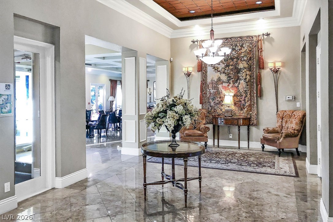 220 East Flamingo Road, Unit 305 Las Vegas, NV 89169 - Photo 20 of 26 Ornate chandeliers illuminate a grand entry with polished stone flooring and intricate wall tapestry.