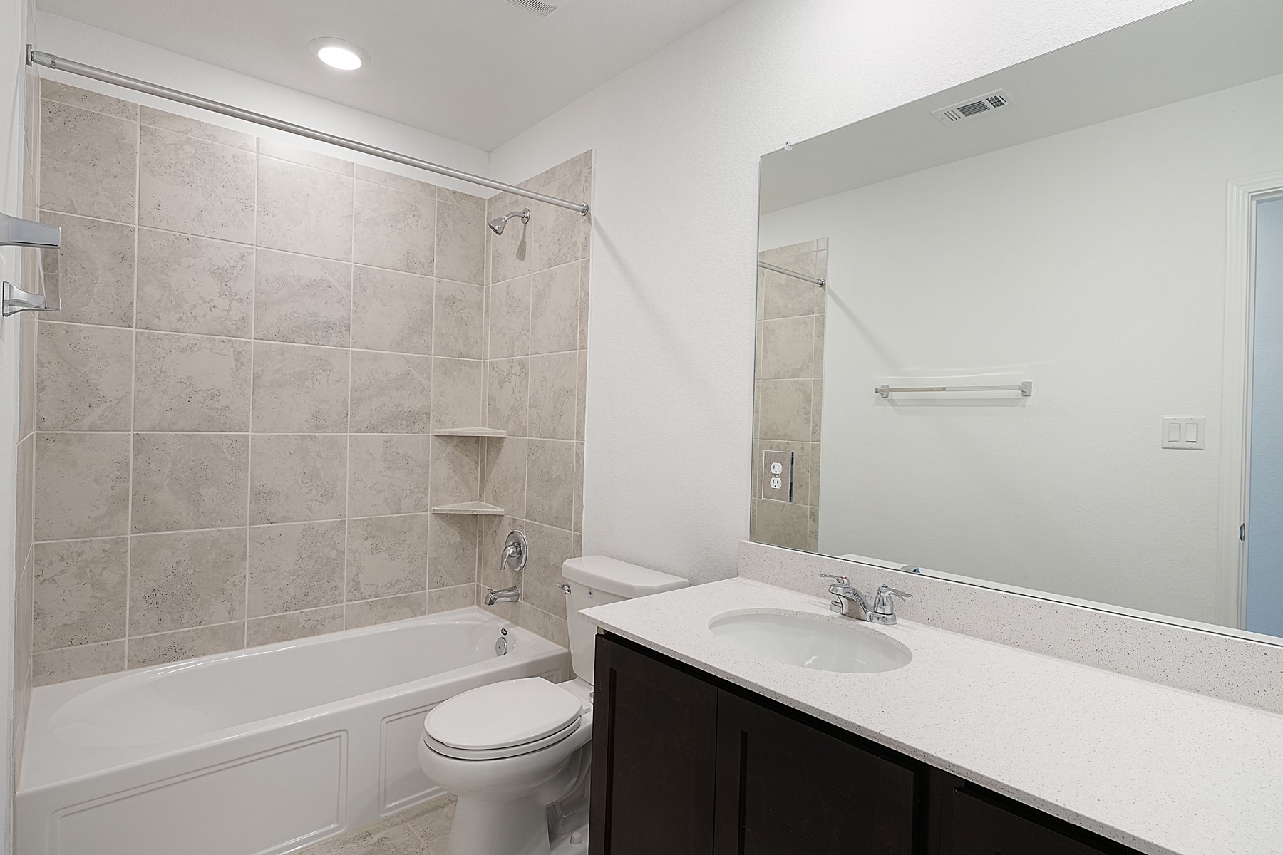 932 Mallow Road Leander, TX 78641 - Photo 27 of 34 A well-appointed bath features a sleek vanity and tiled tub-shower combination.