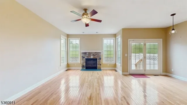 a view of an empty room with window and fire place