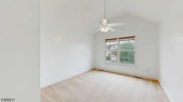 an empty room with a window and a ceiling fan
