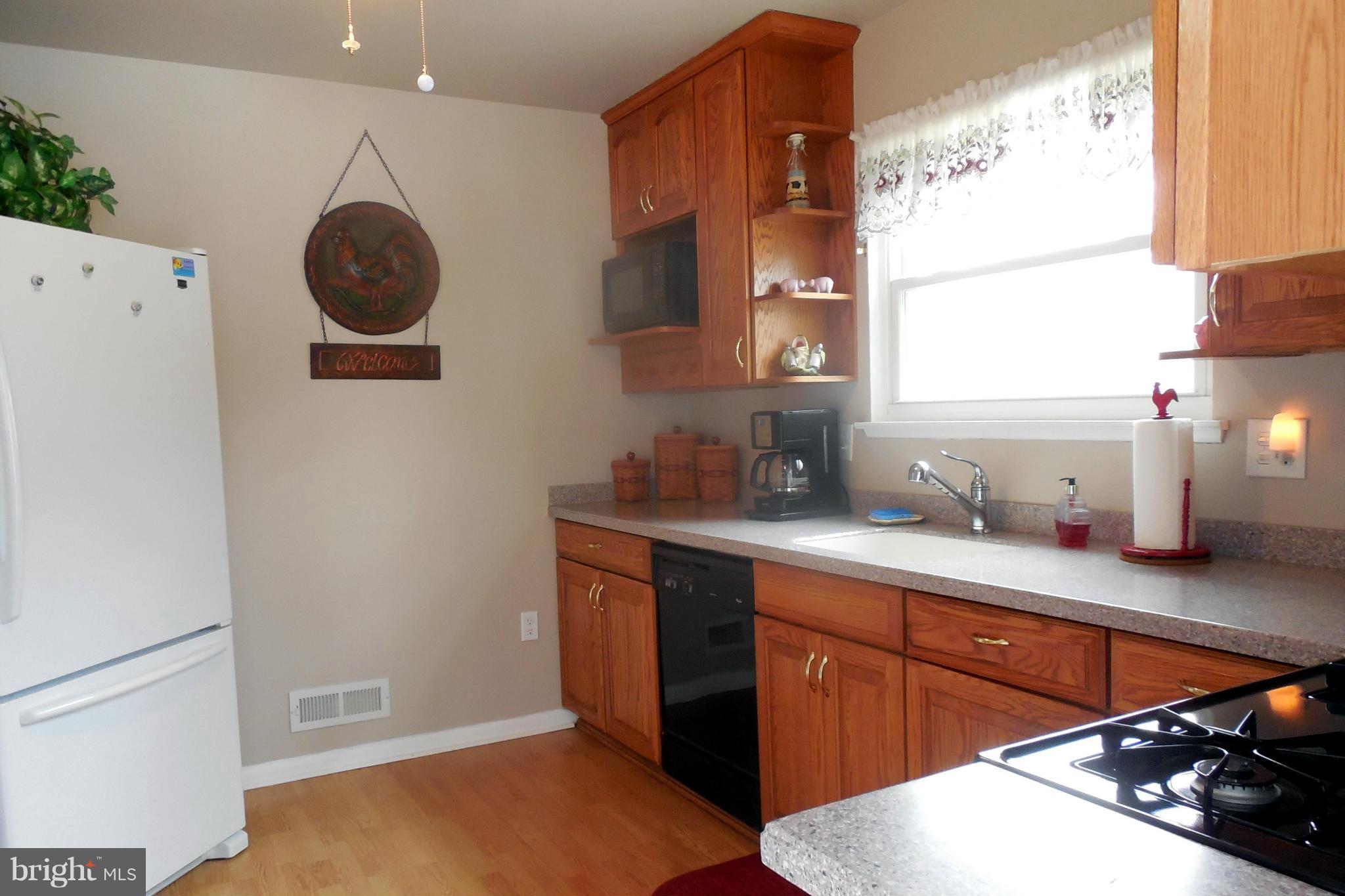 1322 Westburn Road Baltimore, MD 21228 - Photo 15 of 21 a kitchen with stainless steel appliances a sink a stove and a refrigerator with wooden floor