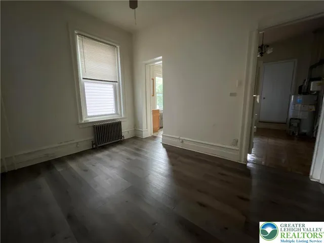 an empty room with wooden floor and a window