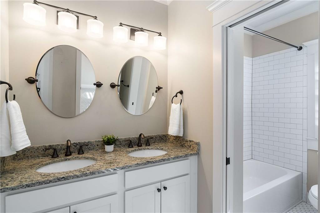 2003 Hibernia Bend Decatur, GA 30030 - Photo 35 of 52 a bathroom with a granite countertop sink a mirror and a bathtub