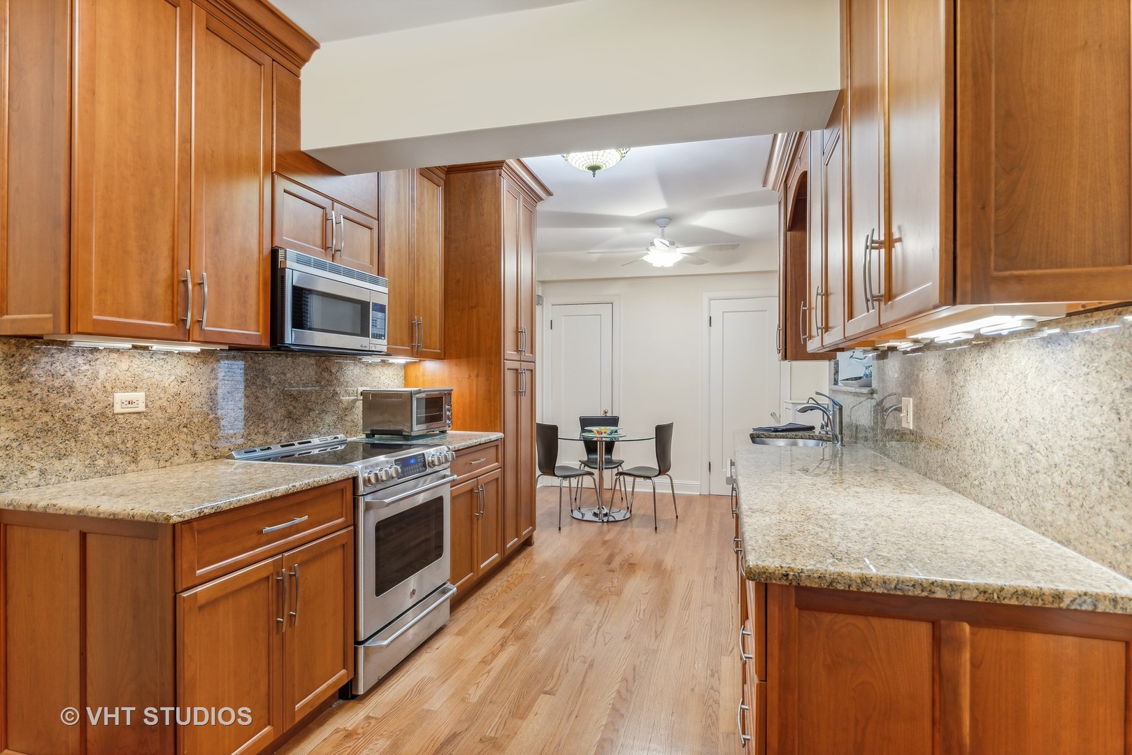 3100 North Sheridan Road, Unit 8B Chicago, IL 60657 - Photo 9 of 28 a kitchen with stainless steel appliances granite countertop a sink stove and wooden cabinets