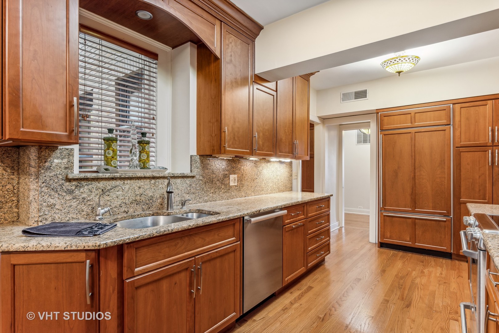 3100 North Sheridan Road, Unit 8B Chicago, IL 60657 - Photo 10 of 28 a kitchen with stainless steel appliances granite countertop wooden cabinets a sink and a hard wood floor