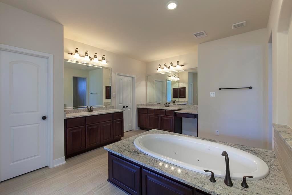 10402 Southern Hawker Conroe, TX 77385 - Photo 11 of 22 a large bathroom with a sink a large mirror and a sink