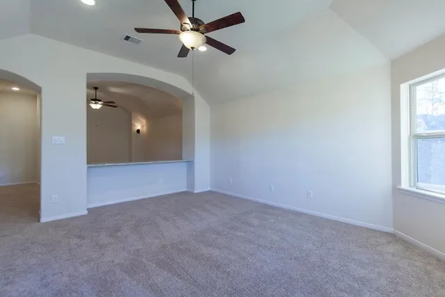 an empty room with windows and fan