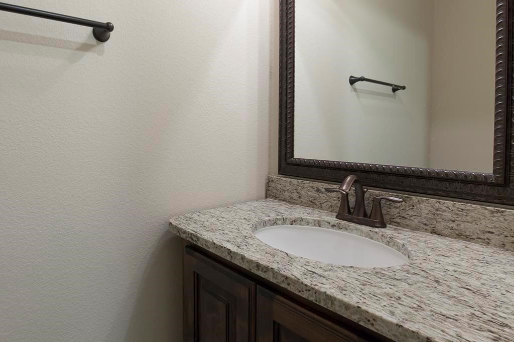 10402 Southern Hawker Conroe, TX 77385 - Photo 16 of 22 a bathroom with a granite countertop sink and a mirror