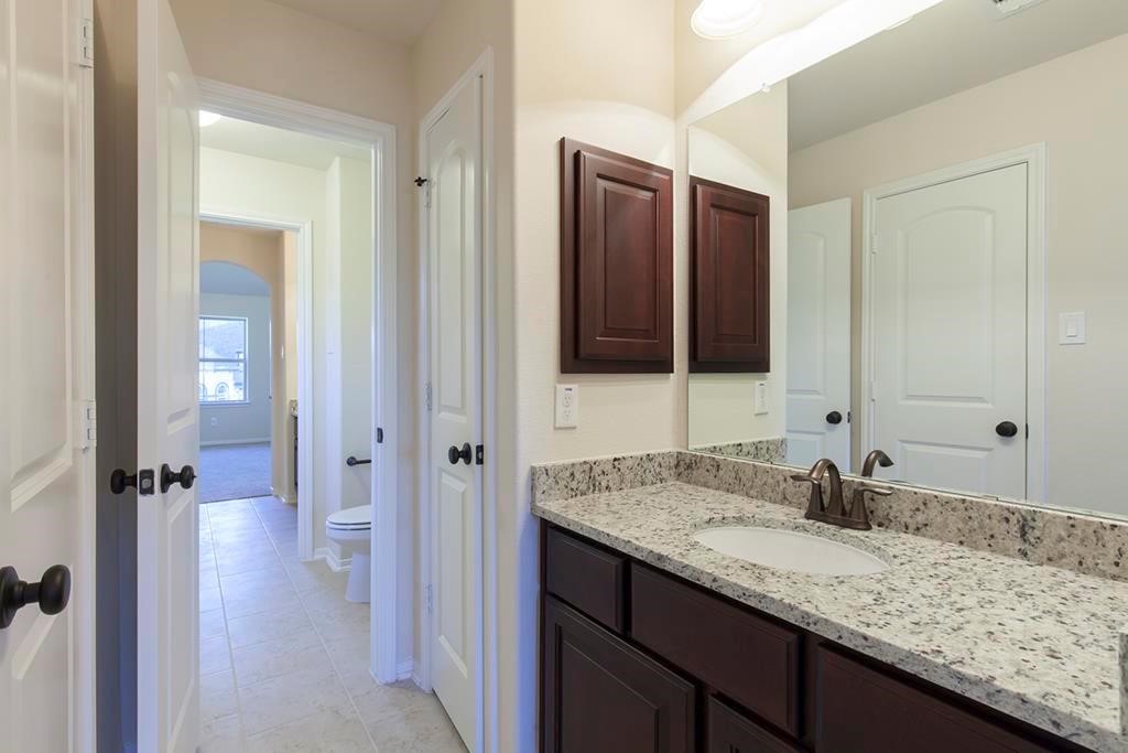 10402 Southern Hawker Conroe, TX 77385 - Photo 19 of 22 a bathroom with a granite countertop sink and a mirror