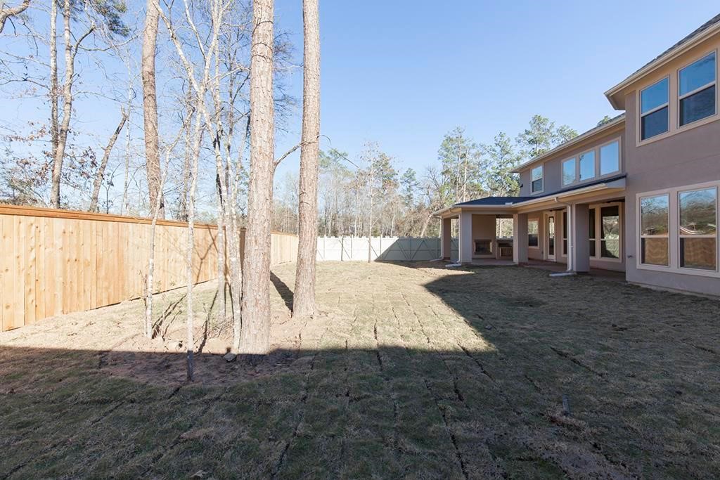 10402 Southern Hawker Conroe, TX 77385 - Photo 22 of 22 a view of a house with backyard and trees