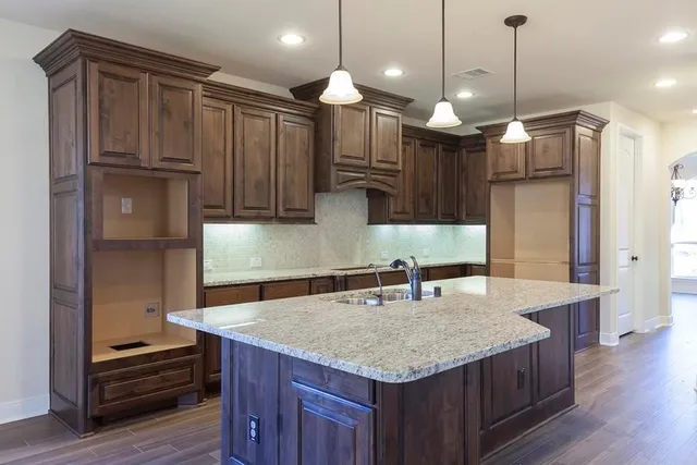 a kitchen with kitchen island a wooden floor and a refrigerator