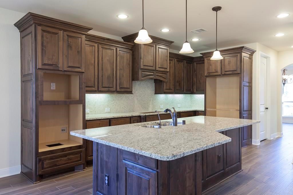 10402 Southern Hawker Conroe, TX 77385 - Photo 5 of 22 a kitchen with kitchen island a wooden floor and a refrigerator