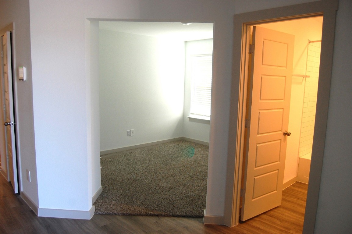7702 Sleek Flock Lane Rosharon, TX 77583 - Photo 3 of 23 a view of an empty room with wooden floor and a window