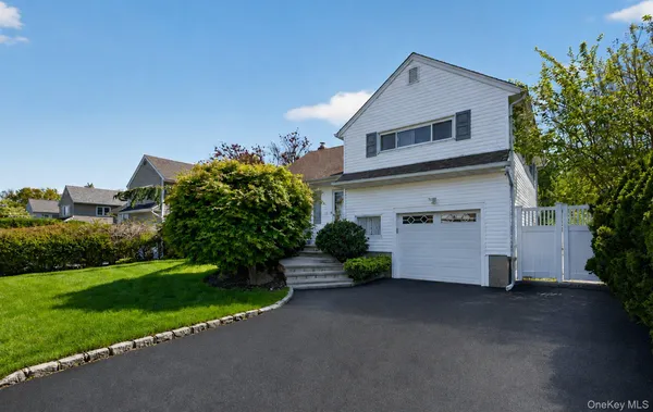 a front view of a house with a yard and a garage