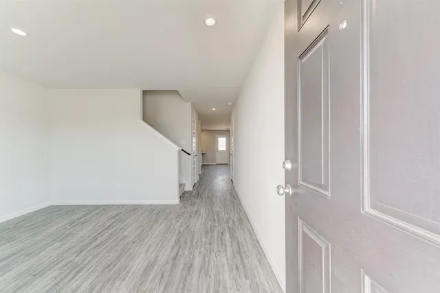 a view of a hallway with wooden floor and staircase