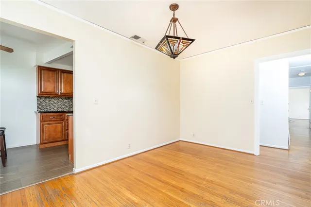 a view of a room with wooden floor and white walls