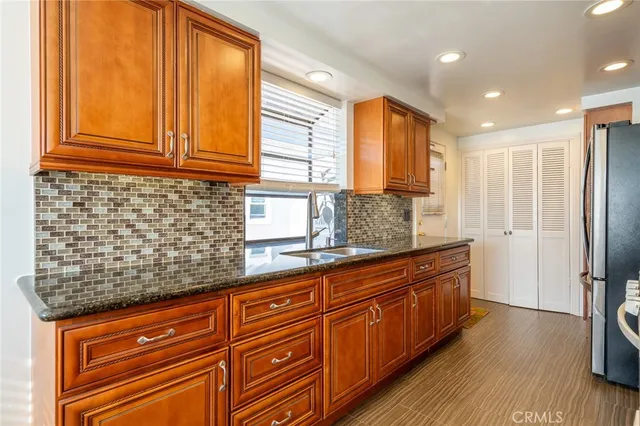 a kitchen with stainless steel appliances granite countertop a sink and wooden cabinets