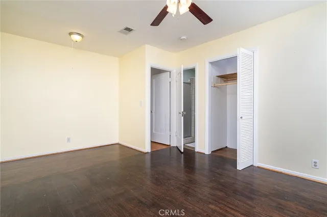 an empty room with wooden floor and natural light